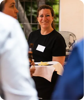 Camarera posa a cámara sosteniendo una bandeja con una copa de cerveza